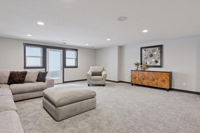 living room featuring recessed lighting, baseboards, and light colored carpet