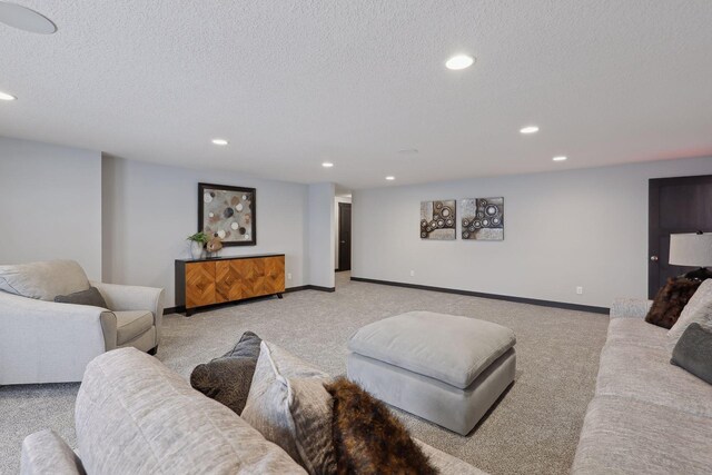 living room with recessed lighting, light colored carpet, a textured ceiling, and baseboards