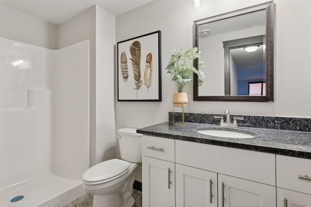 bathroom with toilet, a shower stall, and vanity