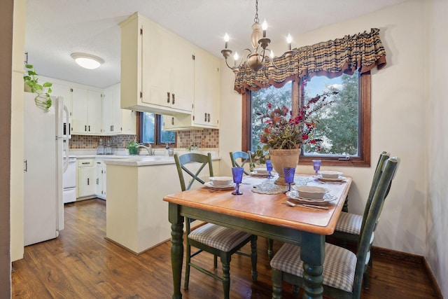 dining room featuring baseboards, an inviting chandelier, dark wood finished floors, and a healthy amount of sunlight