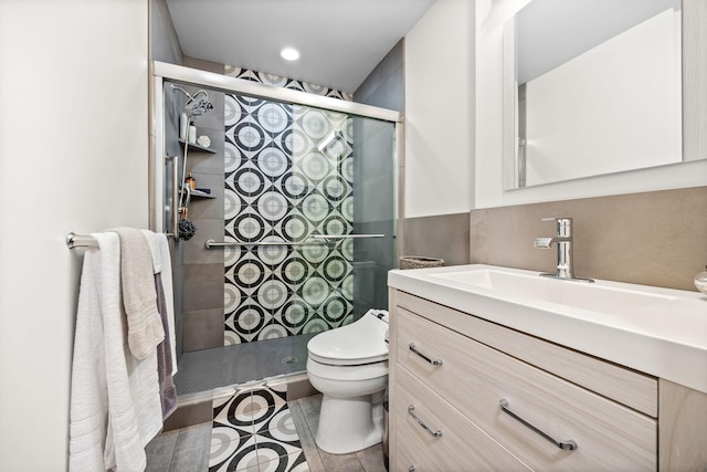 bathroom featuring vanity, an enclosed shower, and toilet