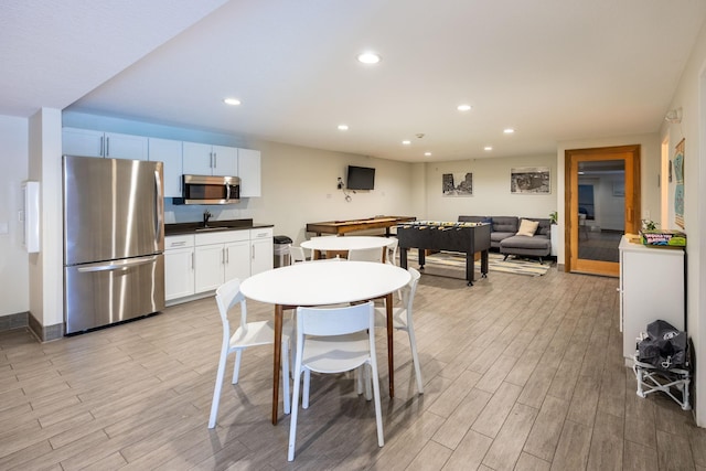 dining space featuring sink and light wood-type flooring