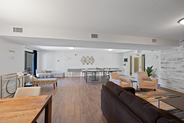 living room featuring wood-type flooring and a textured ceiling