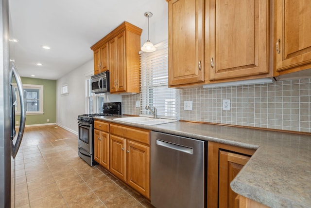 kitchen featuring light tile patterned flooring, sink, decorative light fixtures, stainless steel appliances, and decorative backsplash