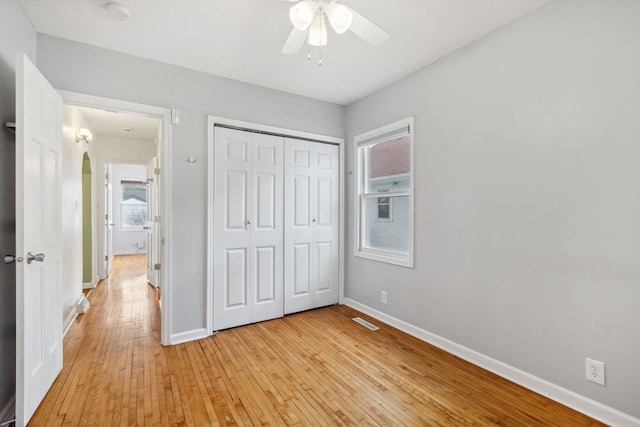 unfurnished bedroom featuring light hardwood / wood-style flooring, ceiling fan, and a closet