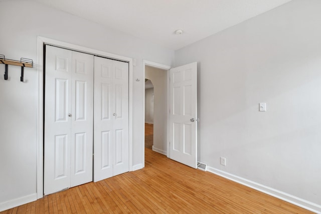 unfurnished bedroom featuring wood-type flooring and a closet