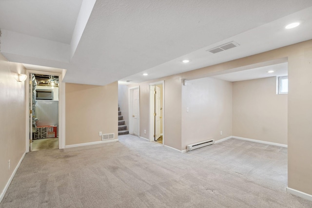 basement with a baseboard heating unit and light colored carpet