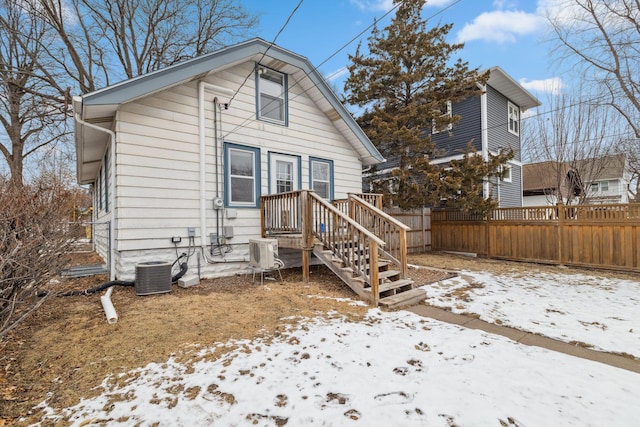 snow covered house featuring ac unit and central air condition unit