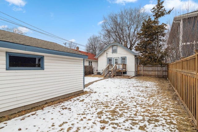 view of snow covered back of property