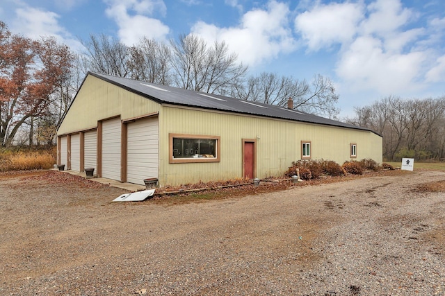 view of side of property featuring a garage and an outbuilding