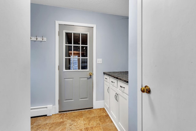 entryway featuring a textured ceiling and a baseboard heating unit