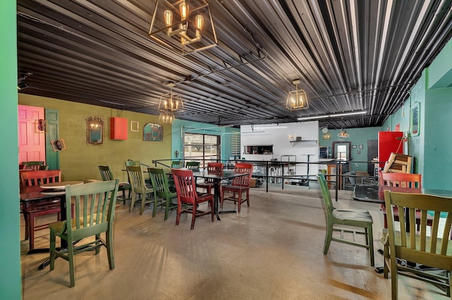 dining room featuring a notable chandelier and concrete flooring