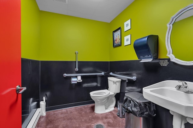 bathroom with toilet, sink, and a baseboard radiator