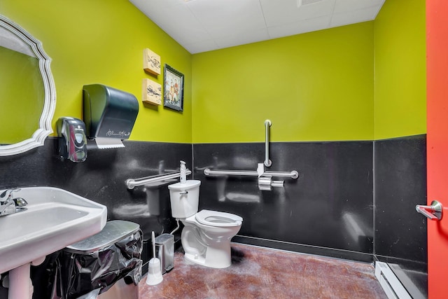 bathroom featuring toilet, baseboard heating, and sink