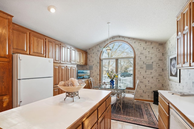 kitchen featuring lofted ceiling, light tile patterned flooring, and white appliances