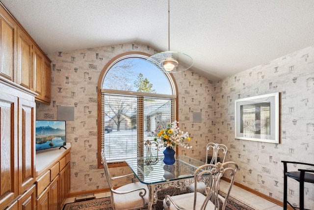 dining space featuring a textured ceiling, vaulted ceiling, and light tile patterned flooring