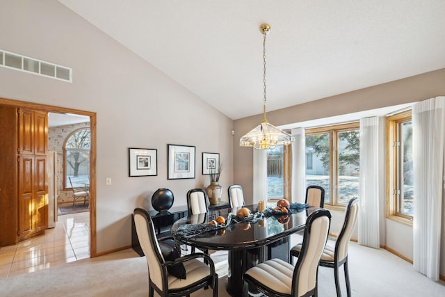 tiled dining space with a notable chandelier, a textured ceiling, and high vaulted ceiling