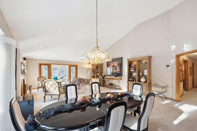 dining space featuring a chandelier, light colored carpet, and high vaulted ceiling