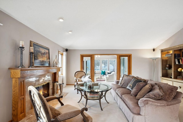 living room featuring light carpet, vaulted ceiling, and a premium fireplace