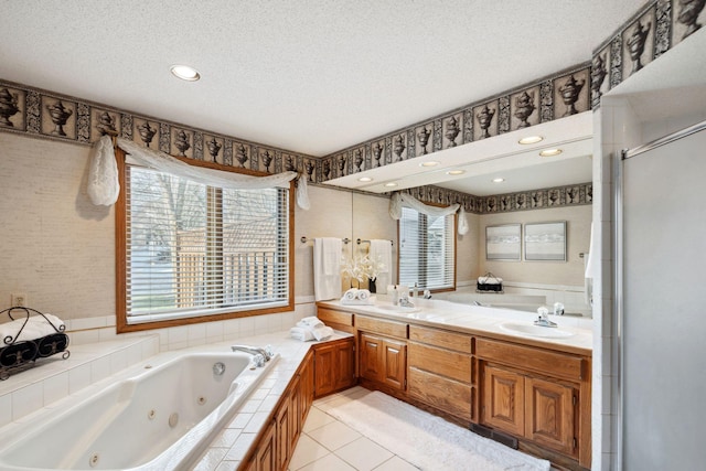 bathroom featuring vanity, a textured ceiling, tile patterned floors, and a healthy amount of sunlight