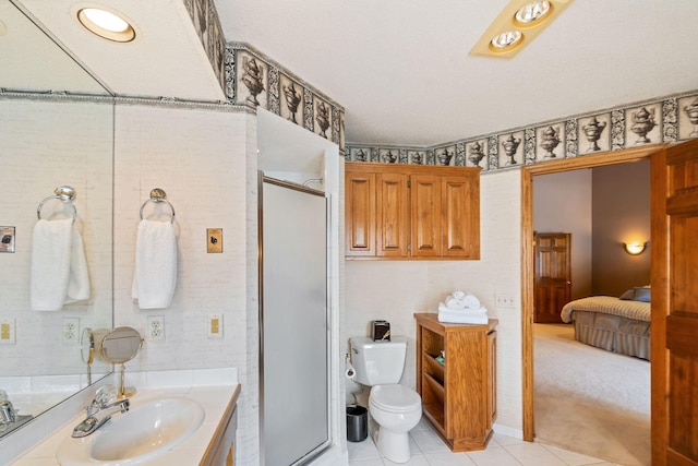 bathroom featuring tile patterned floors, a shower with door, vanity, and toilet