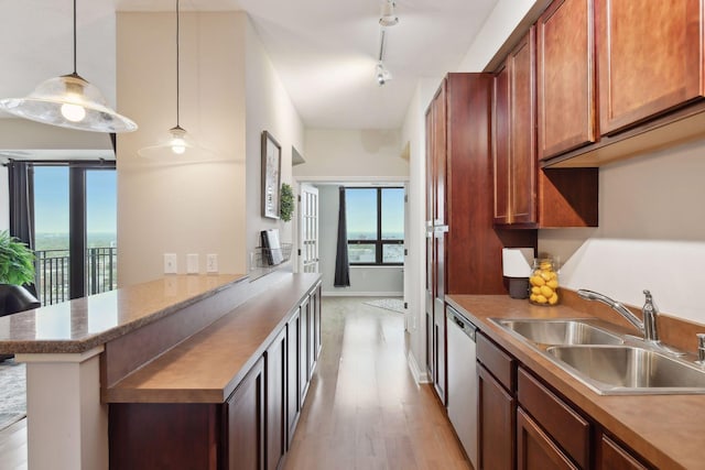 kitchen with pendant lighting, sink, stainless steel dishwasher, light wood-type flooring, and kitchen peninsula