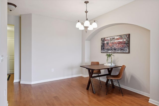 dining area with hardwood / wood-style floors and a chandelier