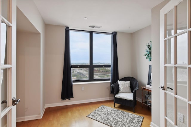 sitting room featuring light wood-type flooring and french doors