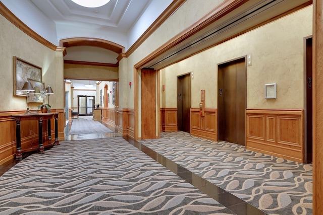 hallway with elevator, ornamental molding, a high ceiling, and dark colored carpet