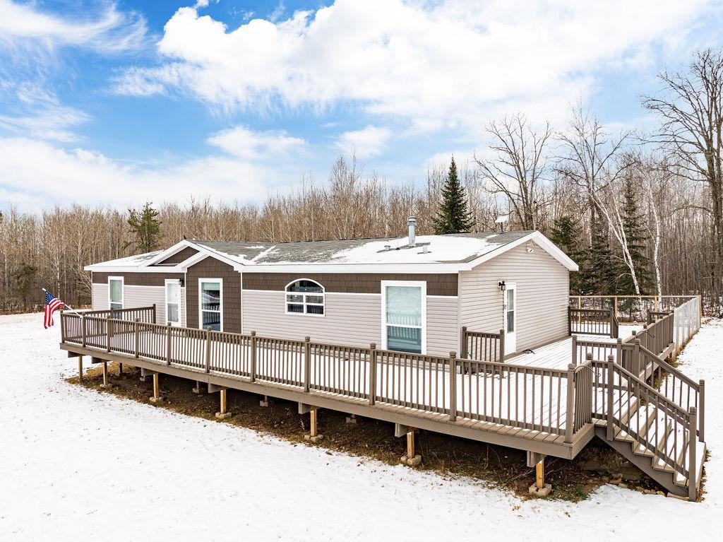 snow covered house featuring a deck