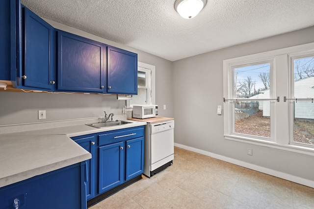 kitchen with a textured ceiling, sink, white appliances, and blue cabinets