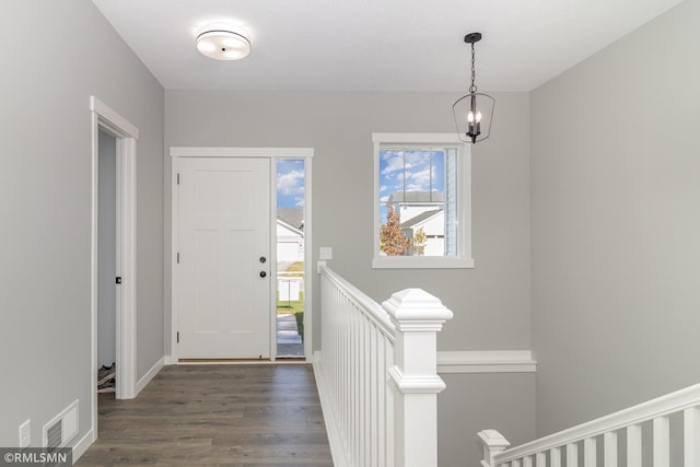 entryway featuring dark hardwood / wood-style flooring and an inviting chandelier