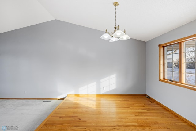 unfurnished room with light wood-type flooring, vaulted ceiling, and a notable chandelier