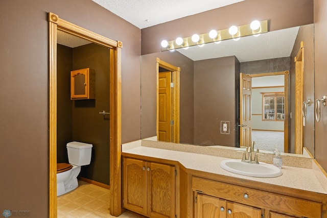 bathroom with vanity, a textured ceiling, and toilet