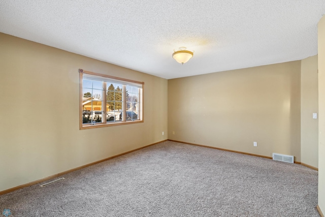 empty room with carpet flooring and a textured ceiling