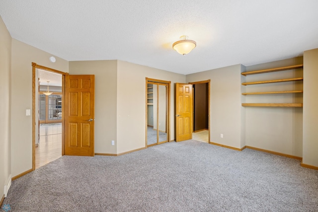 unfurnished bedroom with light colored carpet and a textured ceiling