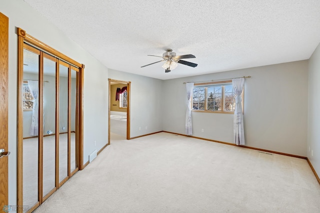 carpeted empty room featuring ceiling fan and a textured ceiling