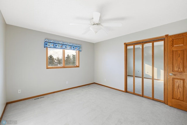 unfurnished bedroom with light carpet, a closet, and ceiling fan