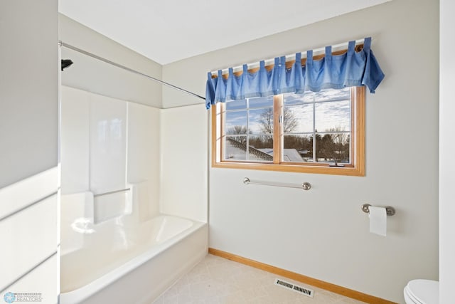 bathroom with bathtub / shower combination and toilet