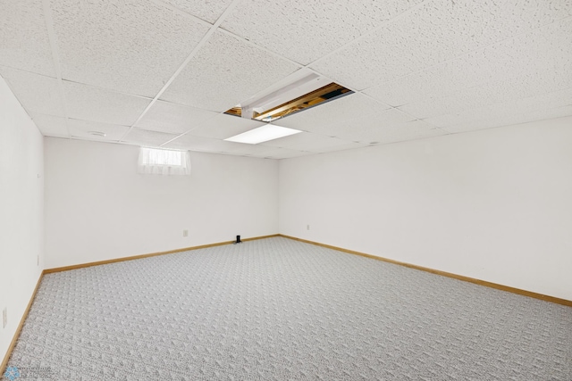 basement featuring carpet flooring and a paneled ceiling