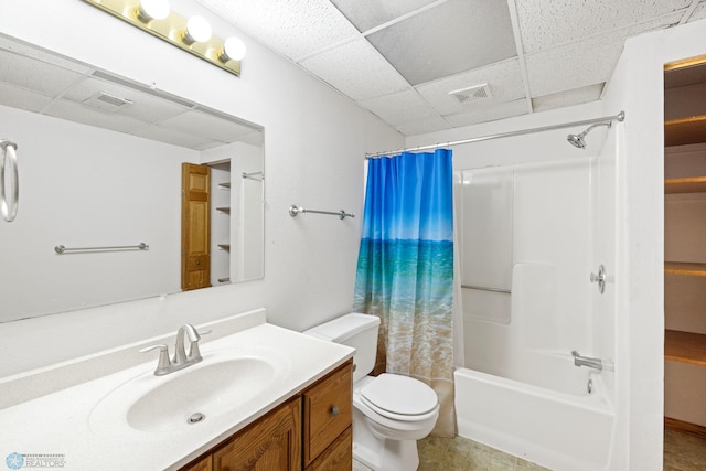 full bathroom with a paneled ceiling, vanity, shower / bath combination with curtain, and toilet