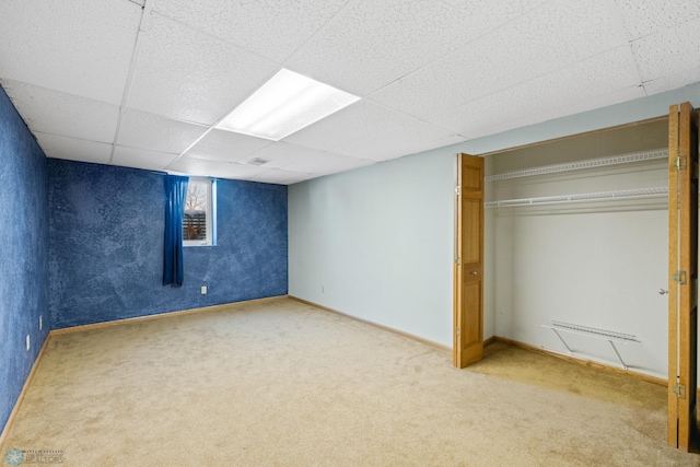 basement with a drop ceiling and carpet floors