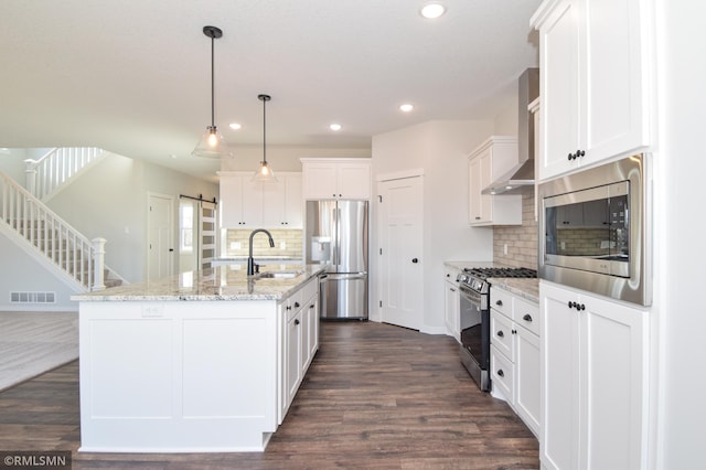 kitchen with wall chimney range hood, sink, dark hardwood / wood-style floors, appliances with stainless steel finishes, and white cabinetry