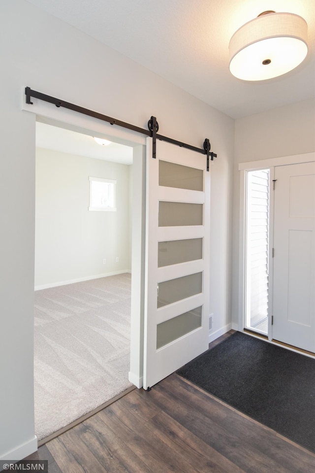 entrance foyer with a barn door and dark hardwood / wood-style flooring