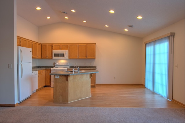 kitchen with lofted ceiling, white appliances, a kitchen island with sink, sink, and light hardwood / wood-style floors