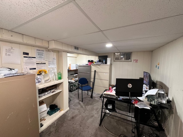 carpeted office with a paneled ceiling