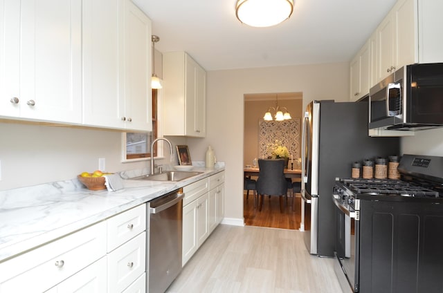 kitchen featuring white cabinets, decorative light fixtures, sink, and stainless steel appliances