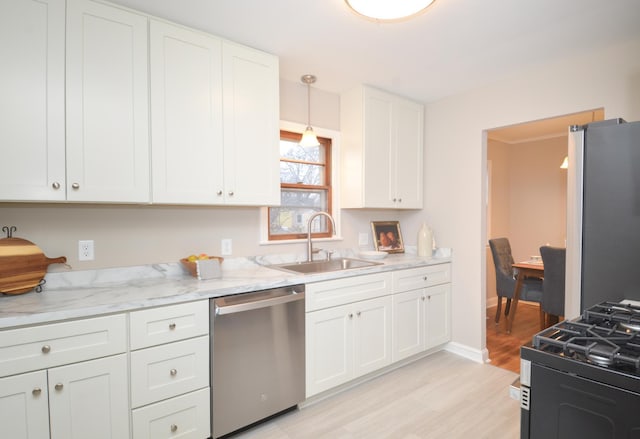 kitchen with light stone countertops, sink, pendant lighting, and appliances with stainless steel finishes