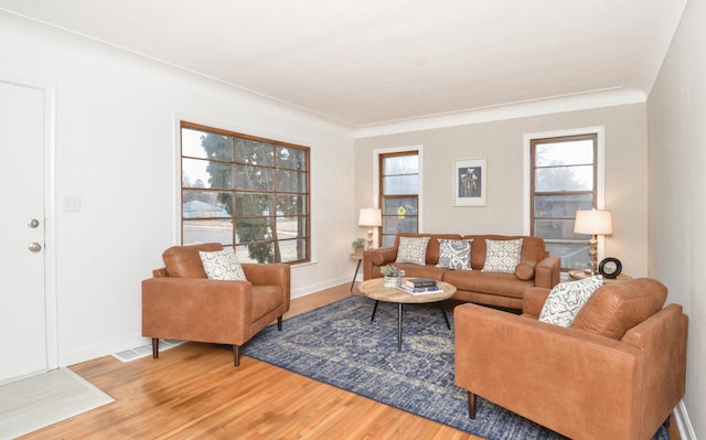 living room with hardwood / wood-style floors and crown molding