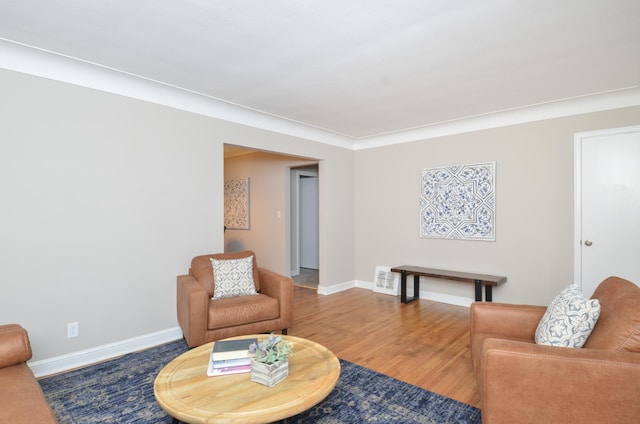 living room with wood-type flooring and ornamental molding